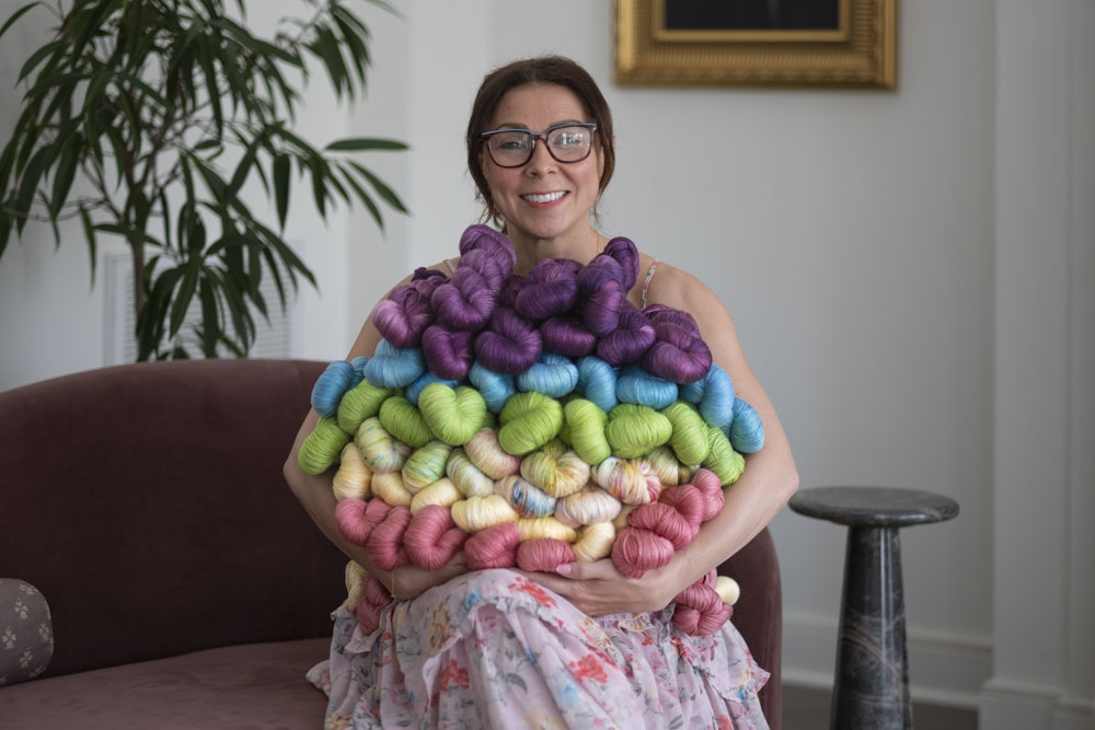 Chandi Agee holding a bundle of hand-dyed yarn in fresh spring colors