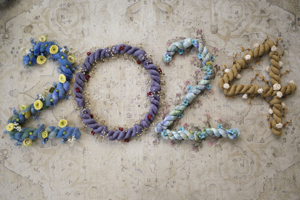 "2024" made with skeins of yarn in blues, purple, multicolored and burnished gold